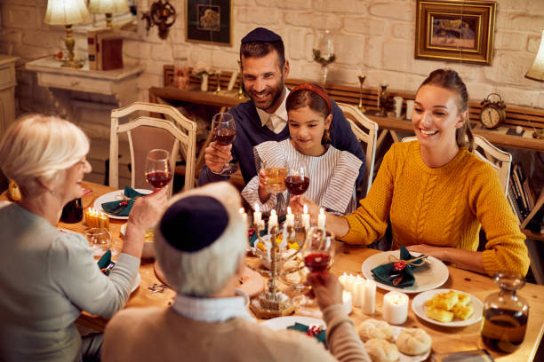 istock Happy extended family toasting at dining table while celebrating Hanukkah. 1337099654