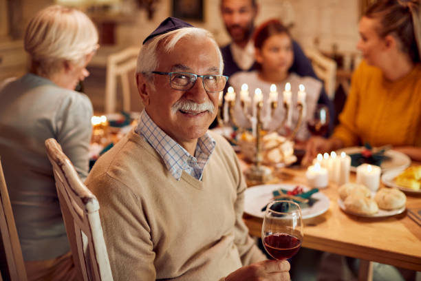 식탁에서 가족과 함께 하누카를 축하하는 행복한 유대인 노인. - hanukkah menorah candle judaism 뉴스 사진 이미지