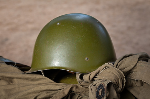A green steel helmet from the Second World War on a raincoat tent. Russia