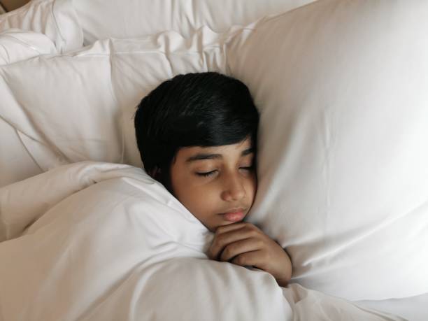 istock Calm cute little child boy sleeping on white bed. 1337102230