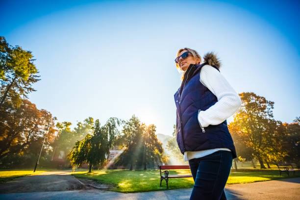 istock Middle-aged woman walking in city park 1337105377