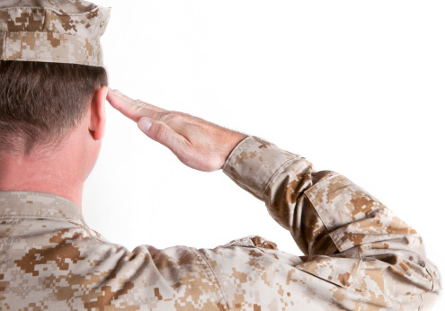 Soldier in a desert uniform is saluting