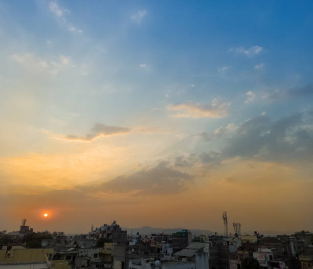 istock Sunrise sunset city view with selective focus on the sun. Rooftop solar panels installed. Empty sky space. 1337109329