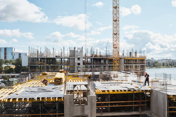 Construction Site Background Wide angle view at construction site with unfinished residential buildings against blue sky, copy space construction site stock pictures, royalty-free photos & images