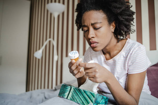 istock Woman with flu in bed blowing nose 1337112091