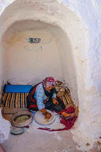 Hammamet, Tunisia  - Oct 2014: Woman is grinding grain in berber house on October 7, 2014 in Hammamet, Tunisia