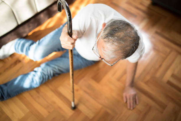 Senior men with cane falled down on floor at home stock photo