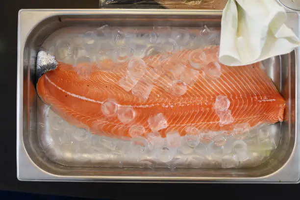 Photo of Red fish in ice. Cooking healthy diet food. Selective focus.