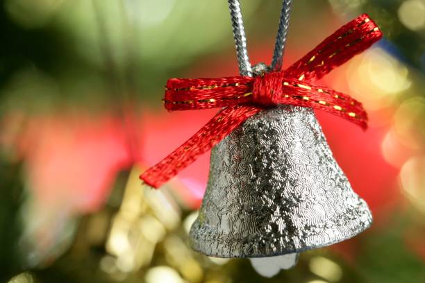 istock Silver bell in the christmas tree with red ribbon 1337134346