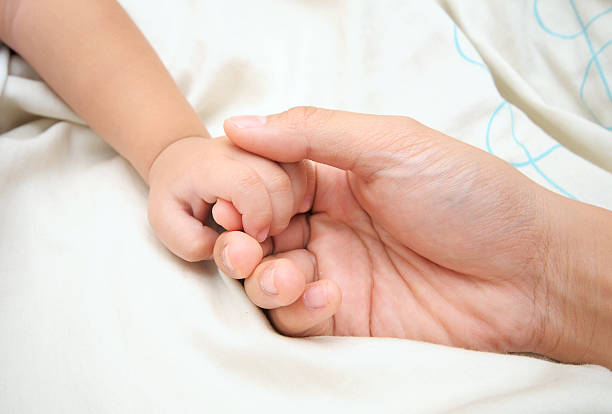 istock Baby hand holding mother finger 133713544