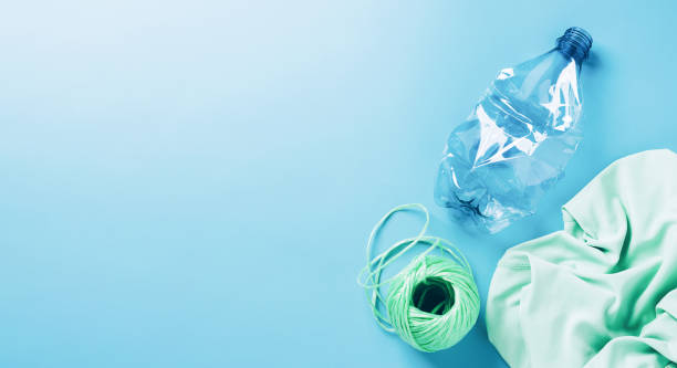 istock The concept recycling plastic. Empty plastic bottle and recycled polyester fiber, synthetic fabric blue background 1337143395