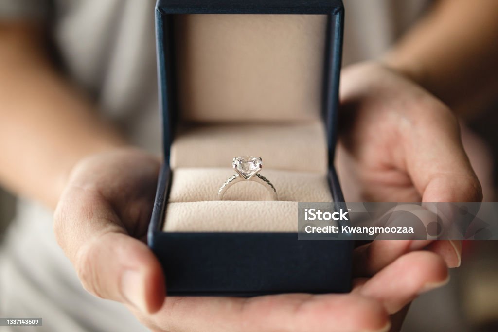 hands holding diamond ring in jewelry box Engagement Stock Photo