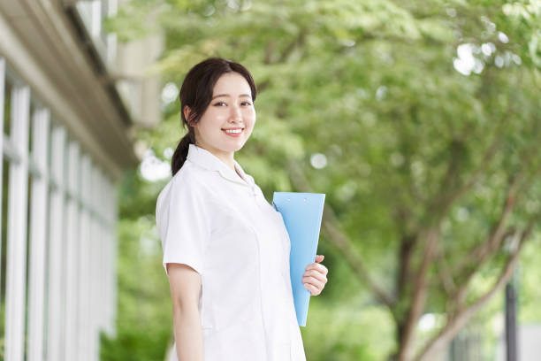 istock Nurse standing with a smile on a green background 1337145737