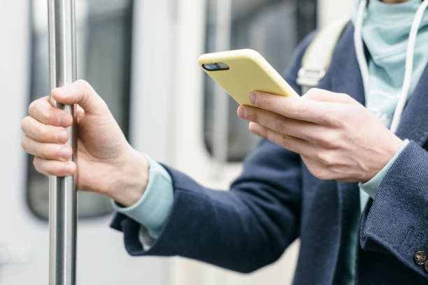 istock Man holding handrail and using smartphone, chatting and sending messages, surfing in the internet. 1337147148