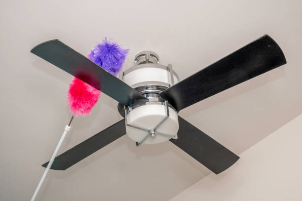 Dusting a fan Colorful duster on dusty bedroom fan ceiling fan stock pictures, royalty-free photos & images