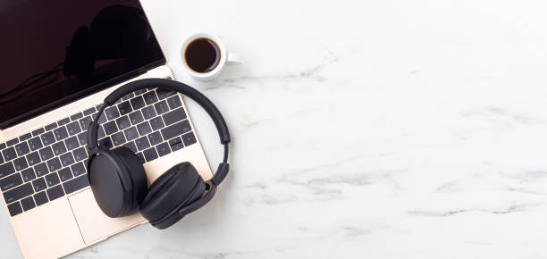 istock Headphone on laptop with coffee cup on marble table 1337167123