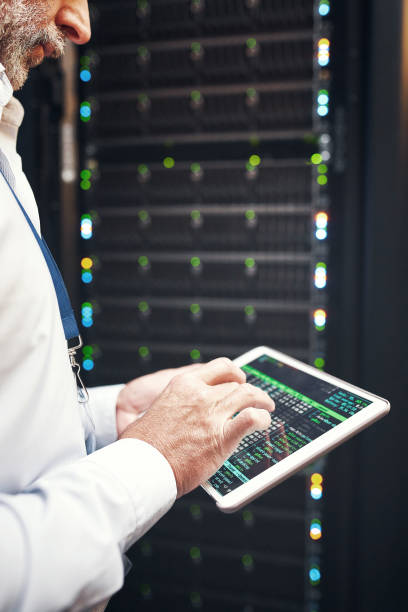 istock Shot of a mature man using a digital tablet while working in a server room 1337171206