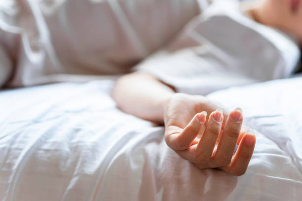 woman committing suicide in bed, focus on the hand of dead body. the concept of die alone. - mental illness depression women schizophrenia imagens e fotografias de stock