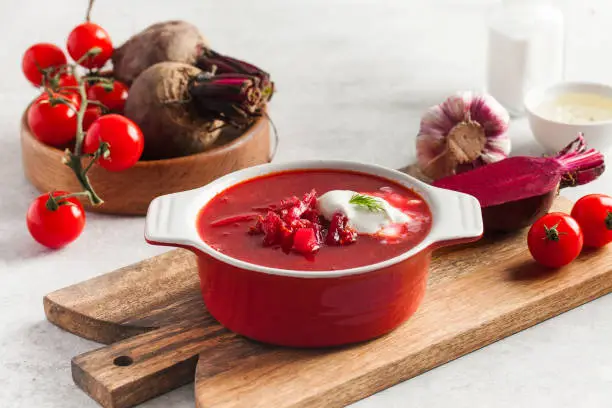Red borscht. Traditional Ukrainian or Russian Delicious fresh red borscht, garlic, tomatoes and beets on the kitchen table.