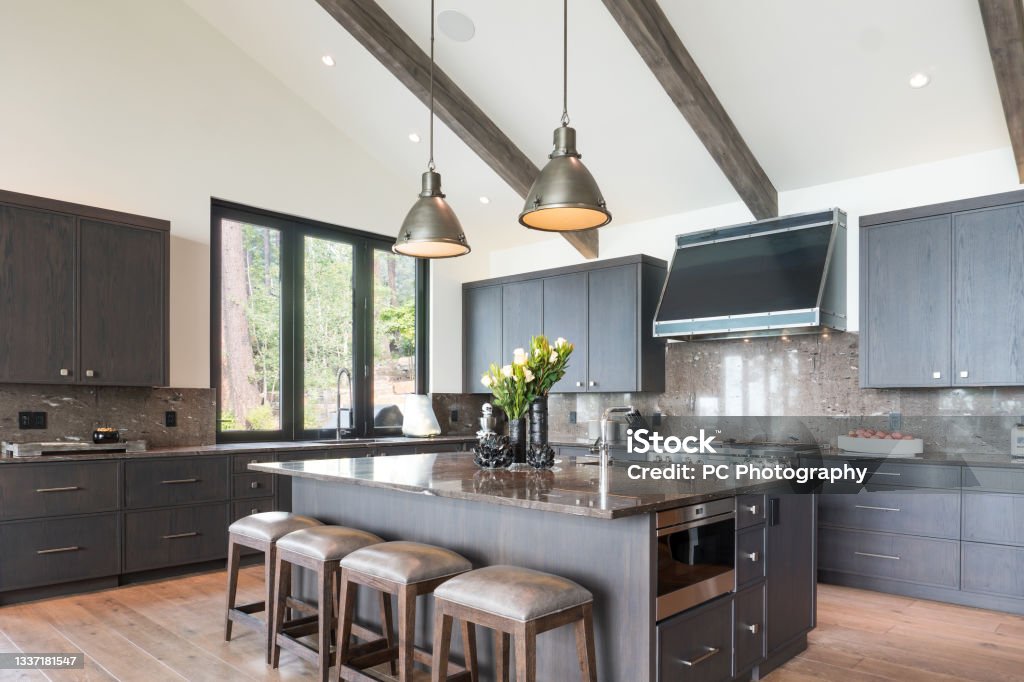 Vaulted ceiling in modern kitchen Kitchen island with four stools and two pendant lights above Kitchen Stock Photo