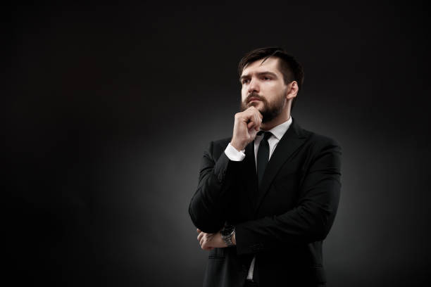 istock Serious businessman holding hand near face 1337181632