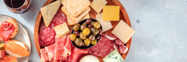 istock Charcuterie and cheese board panorama with red wine and olives 1337182621