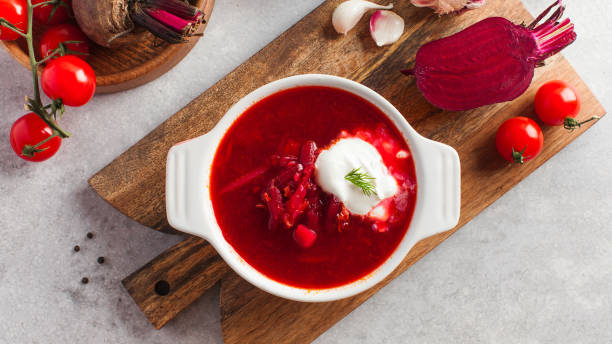 istock Delicious fresh red borscht, garlic, tomatoes and beets on the kitchen table. 1337183394