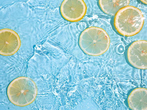 istock Lemon slices in clean transparent water, blue bg 1337186618