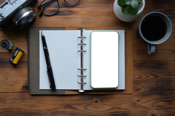 istock Top view, photographer workspace with smart phone, notebook and camera on wooden desk. 1337191269