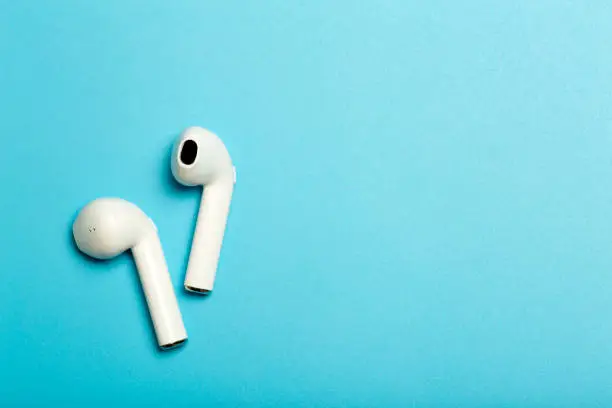 Photo of Wireless sound Audio headphones on a colored background. Music app, listening to podcasts, radio and audiobooks concept.
