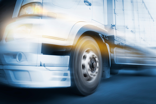 Speed Motion of Cargo Truck Driving on The Road. Truck WheeIs Spinning. Industry Freight Truck Transportation.
