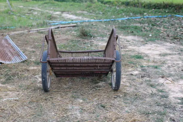 An old rusty cart is placed outdoors.