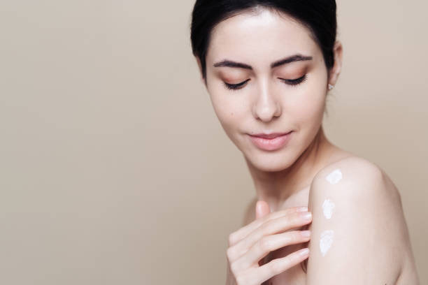 istock Beautiful Caucasian woman applying cream on face 1337199647
