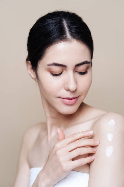 istock Beautiful Caucasian woman applying cream on face 1337199653