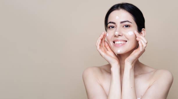 istock Beautiful Caucasian woman applying cream on face 1337199664
