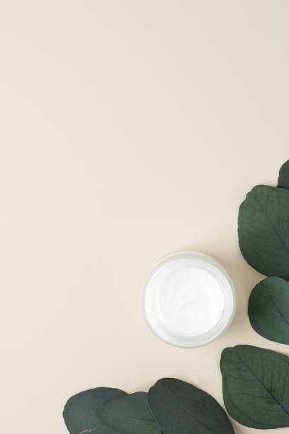 istock Jar of cosmetic cream with eucalyptus on pastel beige background. Flat lay, copy space 1337201828