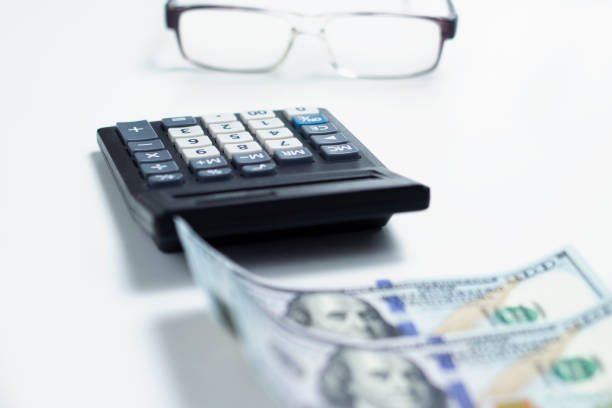 istock Business concept with calculator, money and glasses on white table 1337203775
