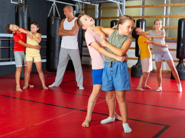 istock Kids exercising elbow strike in gym 1337203989