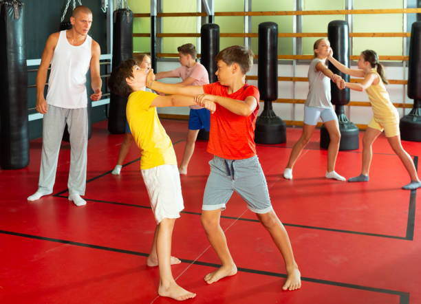 istock Kids in pair exercising self-defense movements 1337204323