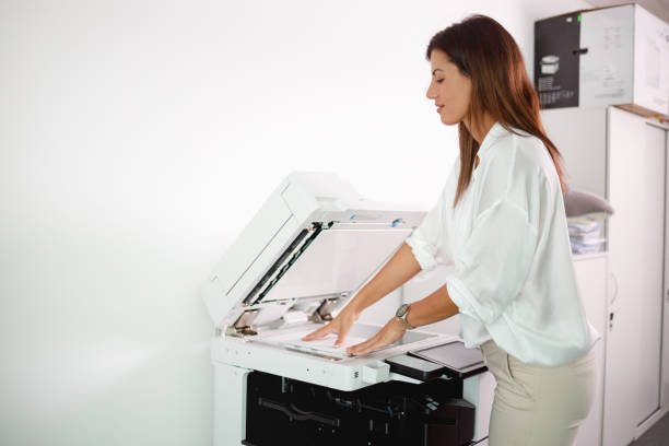 istock Female office clerk making copies of documents on xerox 1337204436