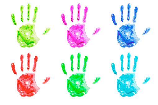 Colored handprints on white paper. Multicolored palm shapes isolate. High quality photo