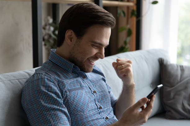 istock Happy male smartphone user excited with text message 1337206366