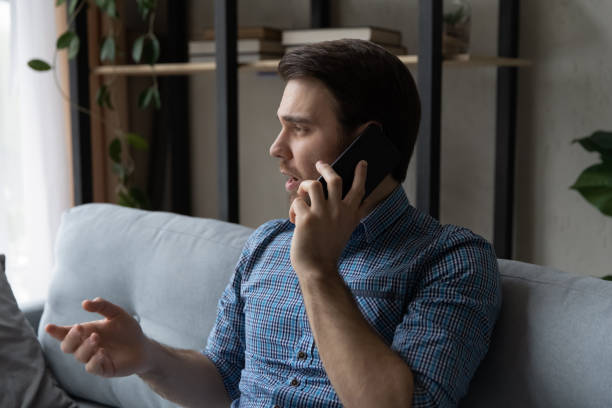 istock Serious thoughtful mobile phone user making telephone call from home 1337206373