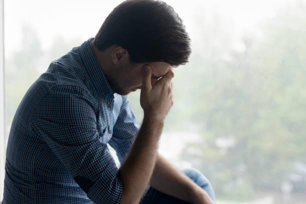 istock Depressed frustrated millennial man touching head, covering face 1337206389