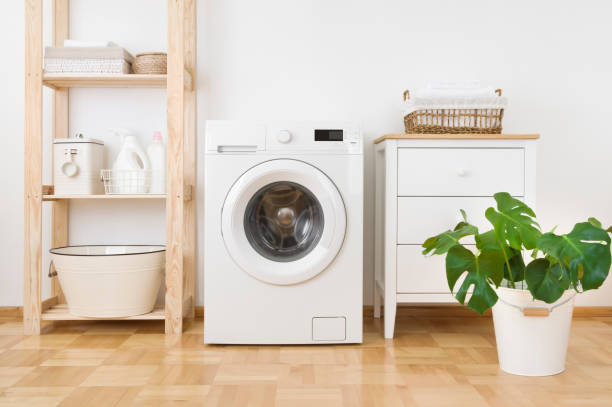 Interior of simple home laundry room with modern washing machine stock photo