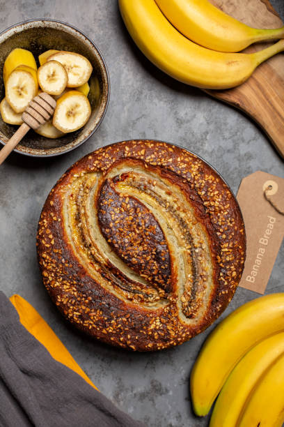 istock Homemade round banana bread with hazelnuts. Grey background, vertical image. 1337206886