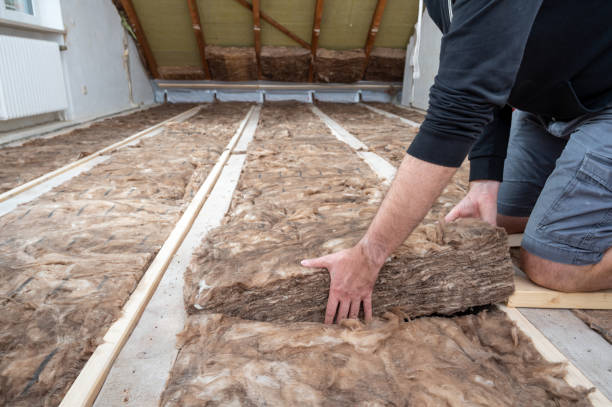 Man insulating the attic with rock wool. stock photo