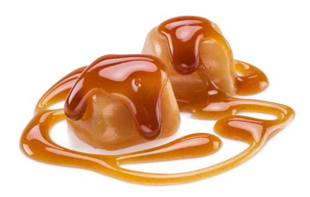 istock Caramel candies covered with melted sugar caramel isolated on white background. 1337209166
