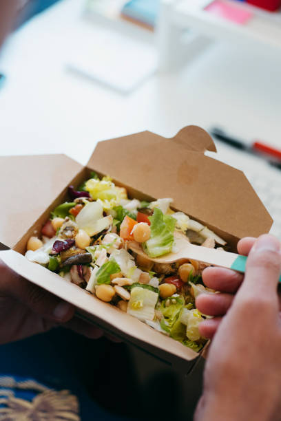 istock man sitting at his desk eats a chickpea salad 1337209487
