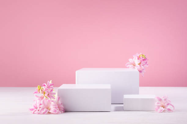 istock White rectangle podiums different size for presentation cosmetic produce or goods with fresh spring flowers and pastel pink background. Template for advertising. 1337210754